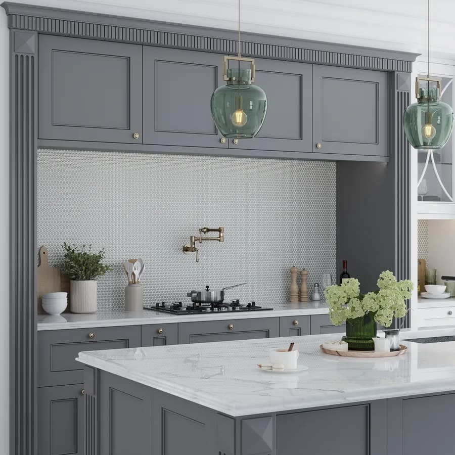 A grey-cabinet kitchen with a white marble island counter and pendant lights