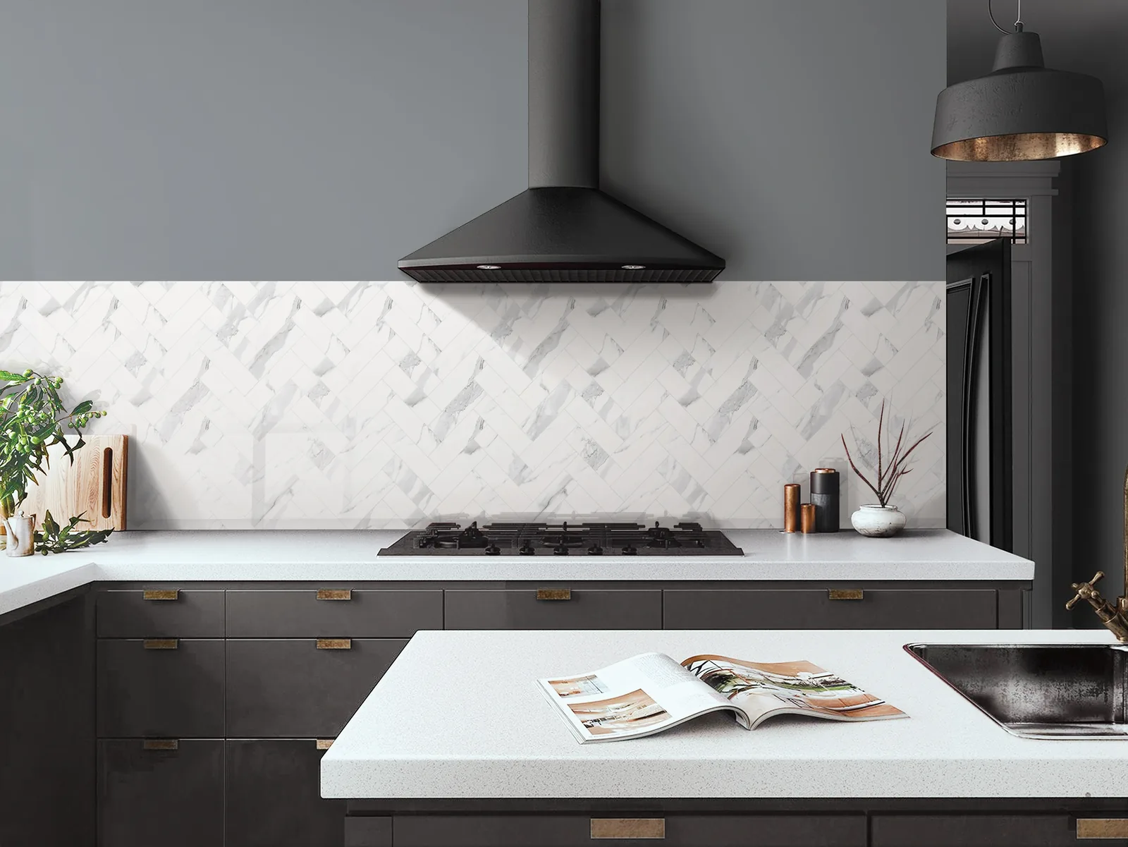 A white stone counter running beneath a marble-look backsplash in a finished kitchen