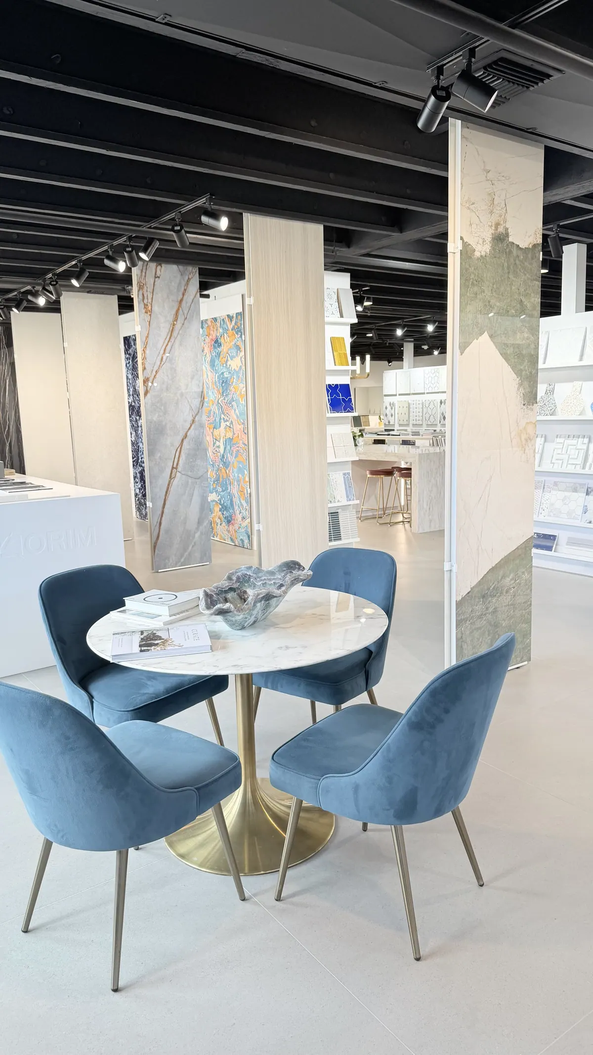 The consultation table in the Segna Tile showroom, surrounded by blue velvet chairs