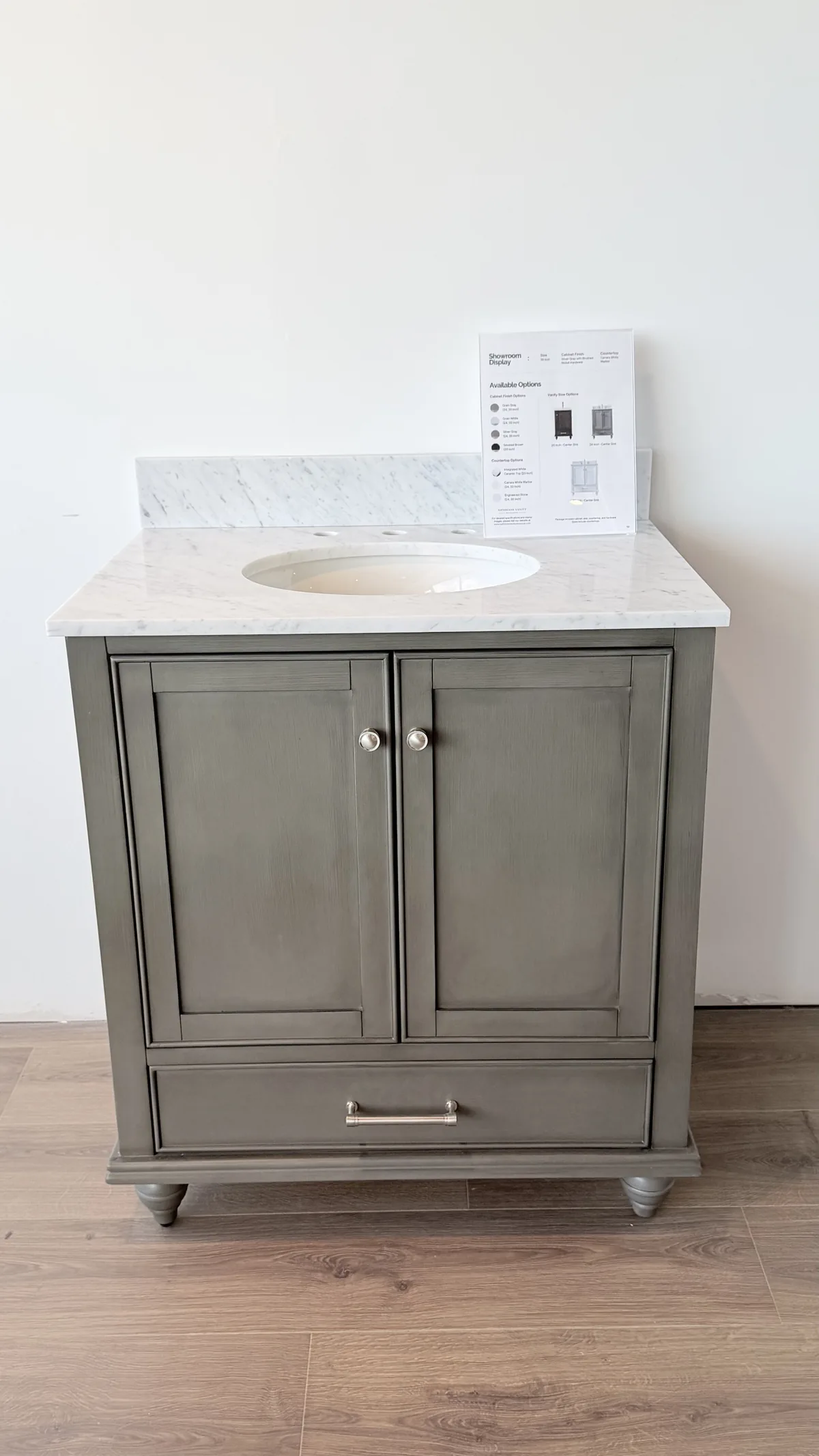 A grey vanity with a white marble top and an undermount basin